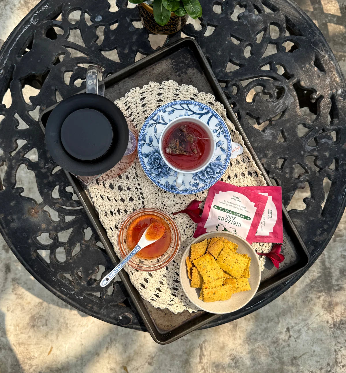 Hibiscus Zing and its pink sachet on a garden table viewed from above