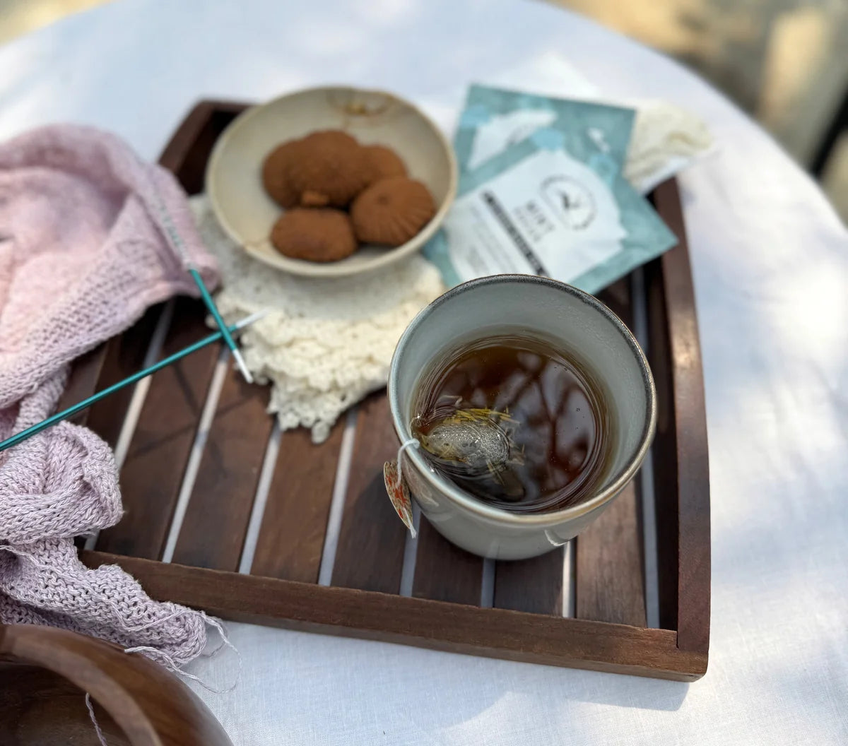 A close view of Mint Focus beside biscuits and knitting