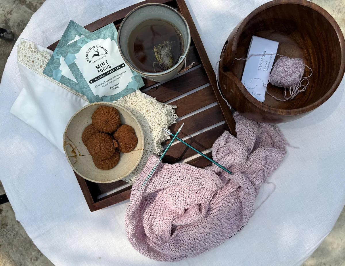 Mint Focus on a mirrored tray with biscuits and knitting