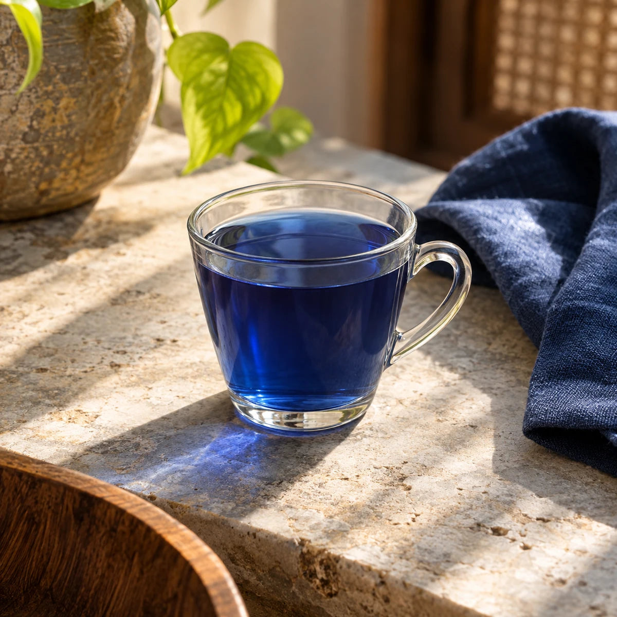 A blue-pea-coloured herbal cup in natural window light