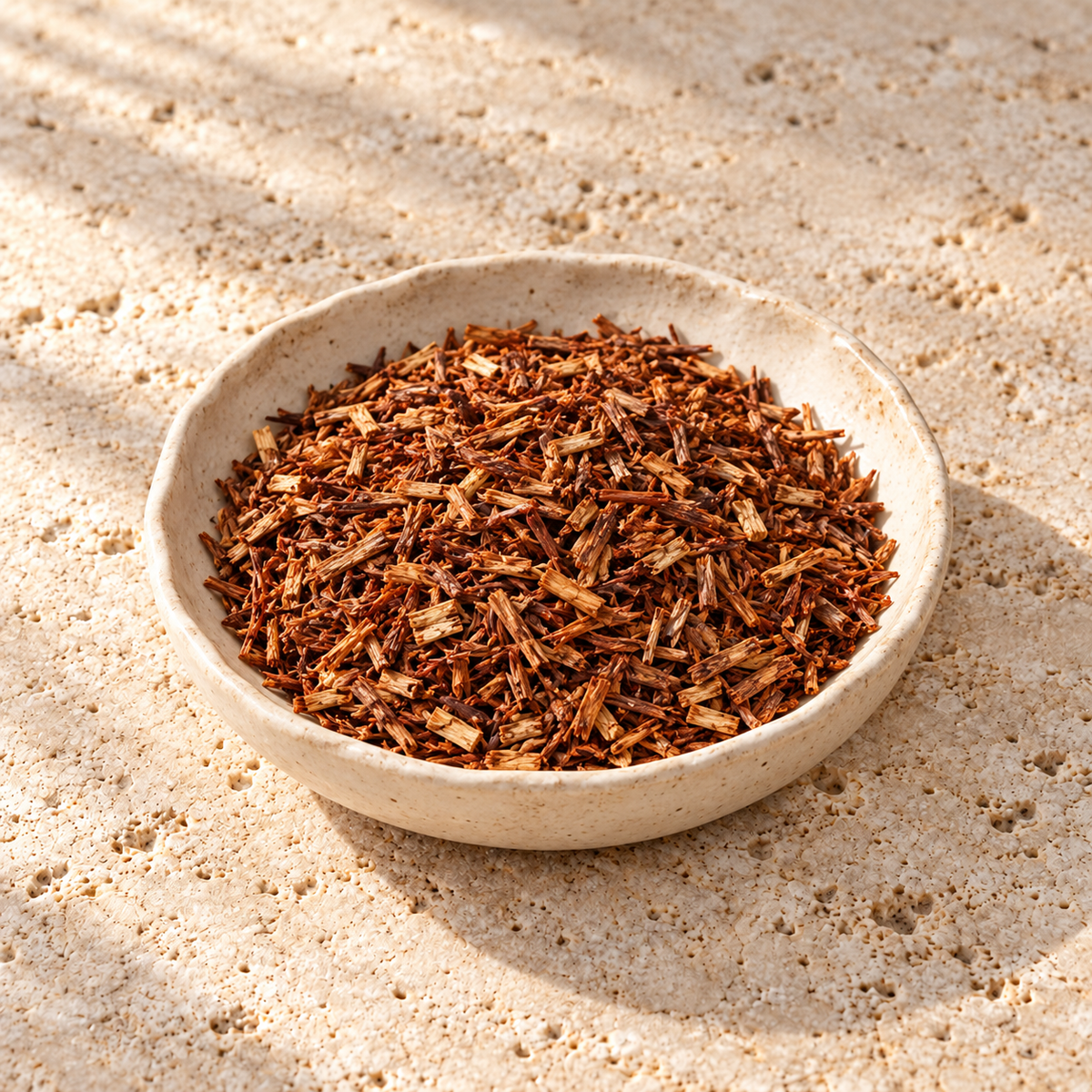 Fine copper-coloured rooibos leaves in a shallow ceramic dish