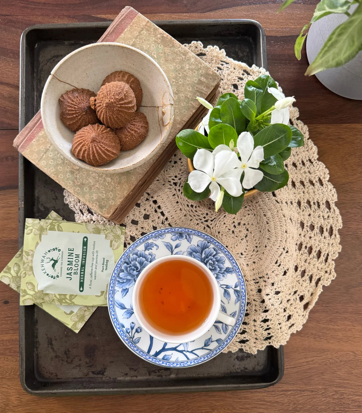 Jasmine Rooibos cups and biscuits on a mirrored tray viewed from above