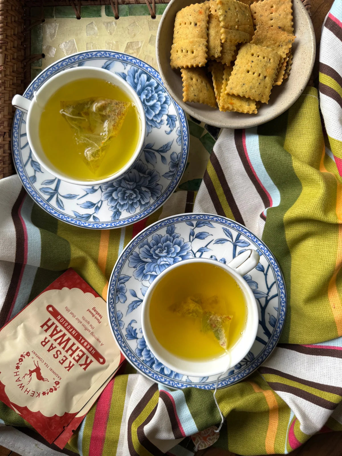 Kesar Kehwah cups and a red sachet arranged on a mirrored tray
