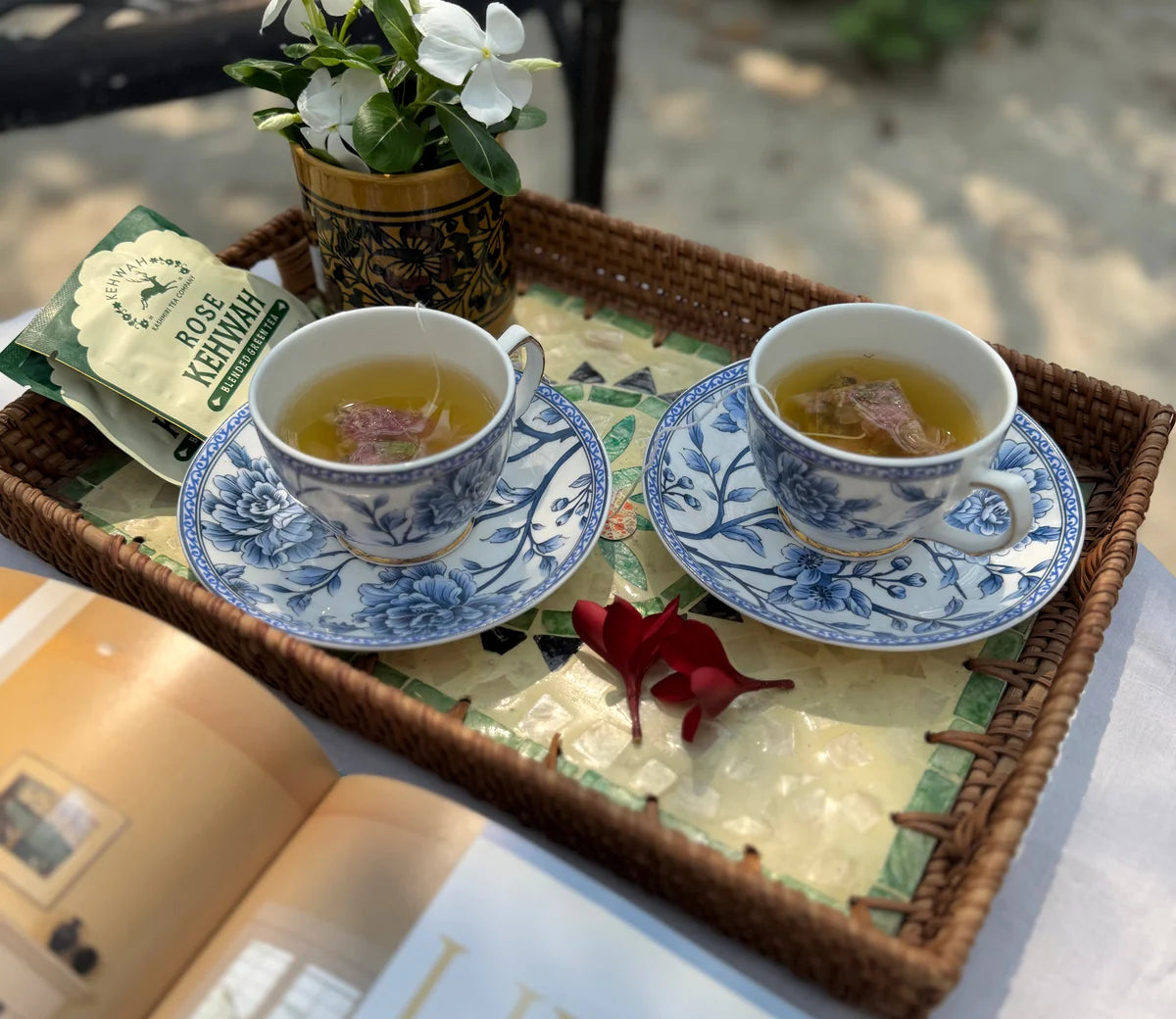 Two cups of Rose Kehwah with rose petals on a mirrored tray