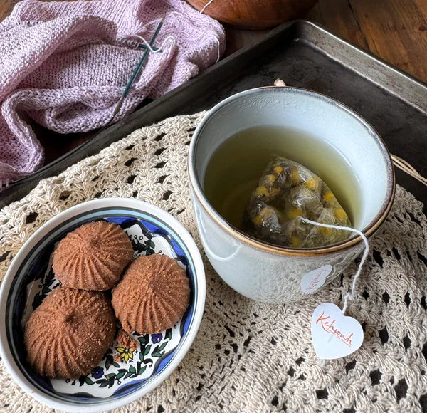 Sleep Aid steeping beside biscuits on a lace-covered table